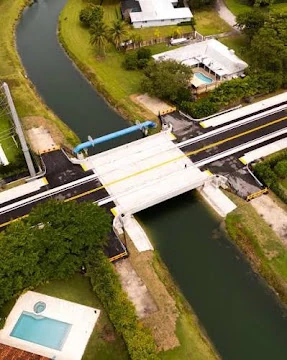 Aerial photograph of a roadway bridge over a narrow canal